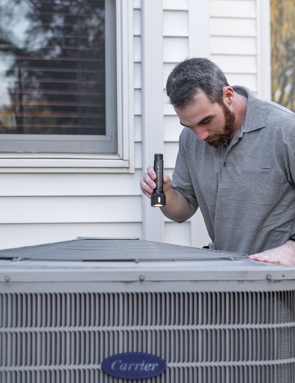 HVAC technician working on an outdoor condenser unit