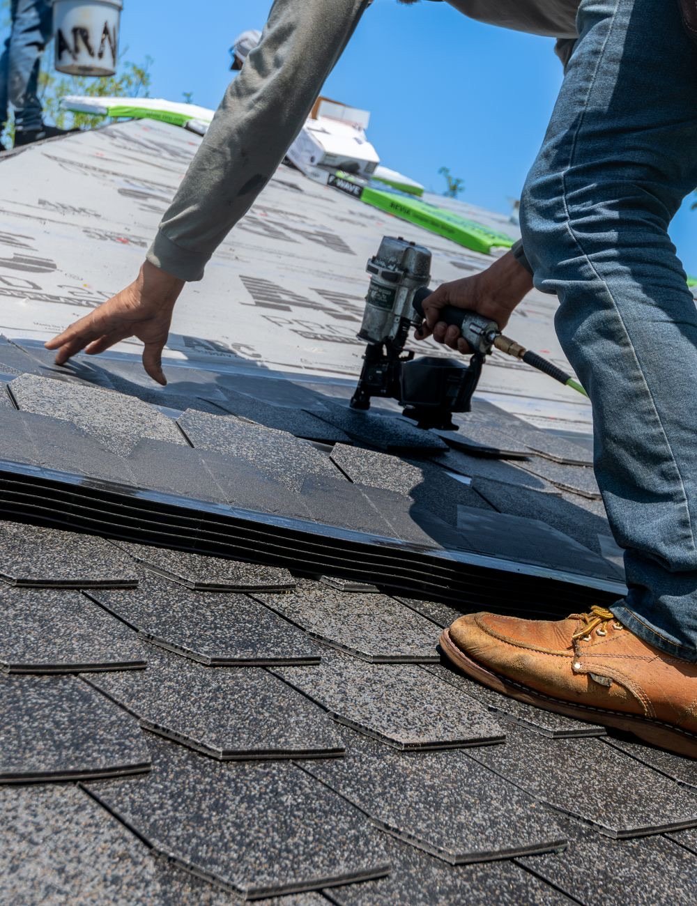 Roofer fitting shingles on a pitched roof